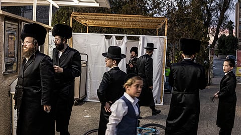 Ultra-Orthodox Jewish men gather outside a synagogue in Arad on October 1, 2026.
