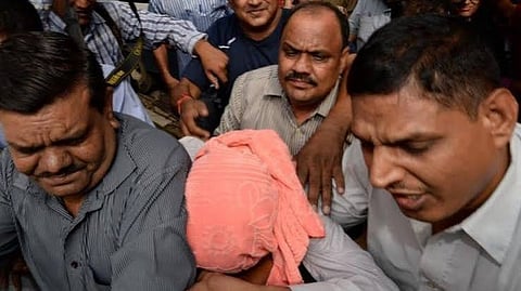 Representative image of a rape accused covering his face