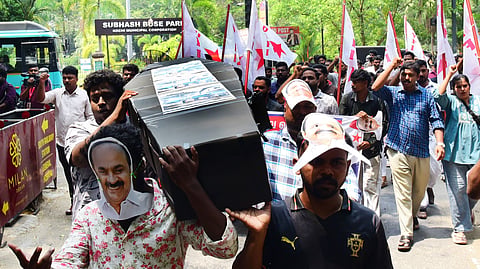 DYFI activists stage a protest march to Ernakulam General Hospital, carrying a coffin and red flags, alleging negligence by the UDF government in the healthcare sector.