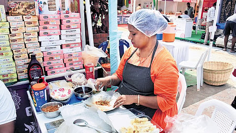 A woman prepares fresh putharekulu at the SARAS Mela-2026 being held at Punnami Ghat in Vijayawada on Wednesday, Oct 14, 2026.