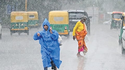 Commuters make their way amid heavy rainfall.