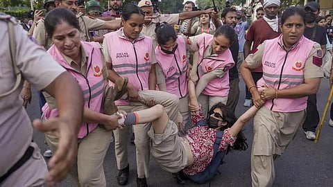 Police personnel detain a woman activist during a demonstration called by the CJP, demanding the resignation of Chief Election Commissioner Gyanesh Kumar over alleged electoral roll irregularities, at Connaught Place in New Delhi, October 10, 2026. 