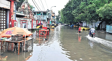 People wade through an inundated street at Pattalam on Sunday; 
