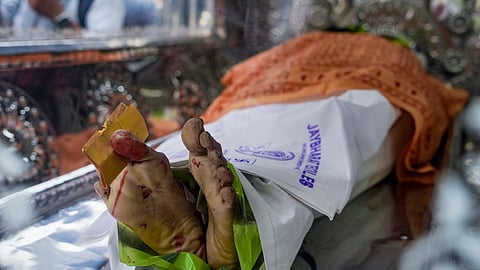 Mortal remains of a victim of the stampede at Chorbagan Sarbojanin Durga Puja pandal are being taken in a dead body carrier vehicle in Kolkata on Sunday, Oct. 18, 2026.