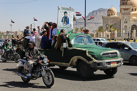 People ride in a pickup truck during a funeral procession for a Houthi officer in Sanaa, Yemen, Saturday, Oct. 17, 2026. The Arabic banner reads, "Martyr Mazen Abdallah." 