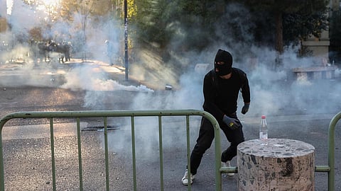 A protester runs during clashes with police during an anti-government protest by students in Tirana, Albania, October 18, 2026.