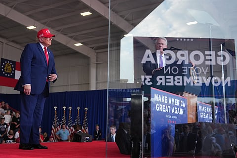 President Donald Trump listens as Georgia U.S. Senate candidate Rep. Mike Collins, R-Ga., speaks at a campaign rally at Dalton Municipal Airport, Friday, Oct. 16, 2026, in Dalton Ga.