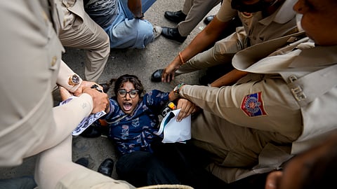 Security personnel detain an activist during a protest demanding the resignation of Chief Election Commissioner Gyanesh Kumar over the Special Intensive Revision (SIR) of electoral rolls, in New Delhi, Friday, Oct. 23, 2026.