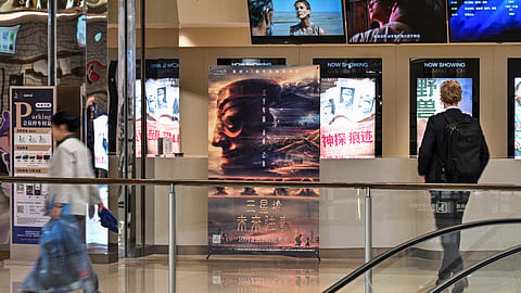 People walk next to a poster of the AI-generated movie "Sanxingdui: Future Memories" in a cinema in the Jing'an Temple district in Shanghai on October 22, 2026.