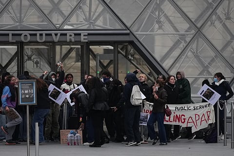 Workers block the entrance of the Louvre museum during a protests against rising living costs, in Paris, Monday, Oct. 19, 2026.