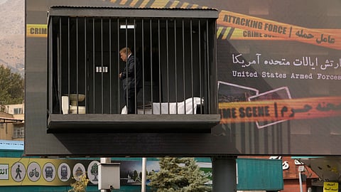 An actor portraying US President Donald Trump walks behind bars in a billboard installation resembling a prison cell in Tajrish Square in Tehran, Iran, Friday, Oct. 23, 2026. 