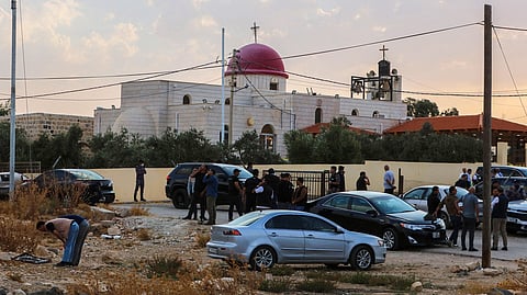 People and security forces gather outside a Greek Orthodox Church in the village of Hammoud in Jordan's Karak governorate following a shooting on October 23, 2026.