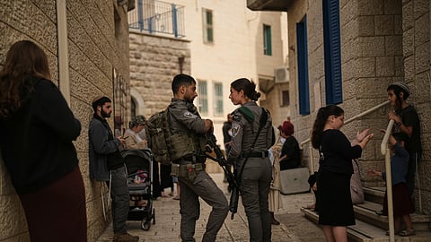 Israeli settlers and border police officers line up to vote outside a polling station during Israel's general election in Hebron, West Bank, Tuesday, Oct. 27, 2026.