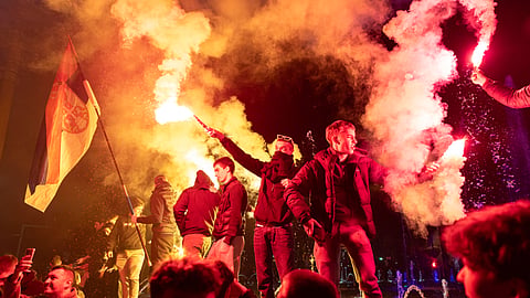 Youths light flares as people celebrate on a street a day after the student-led opposition won at the parliamentary elections in Belgrade, Serbia, Monday, Oct. 26, 2026.