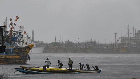 Fishermen secure their boats at a fishing harbour amidst heavy rain under overcast skies, ahead of severe cyclonic storm 'Arnab', in Visakhapatnam, Andhra Pradesh