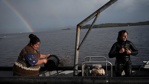 Yesica Fabiana Leviñanco, left, and her partner, Paulo Vera Perez, prepare for a fishing journey in Repollal, in the Guaitecas Archipelago, Chile, Wednesday, May 21, 2025.