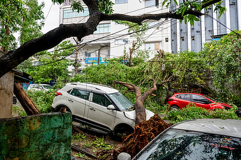 A tree lies uprooted over a car following heavy rainfall and strong winds triggered by Cyclone 'Arnab', in Visakhapatnam, Andhra Pradesh, Wednesday, Oct. 28, 2026.