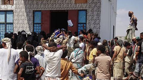 Yemenis displaced by fighting in Taiz gather to receive food aid in the Salah al-Din area on the outskirts of Aden, Yemen, Sunday, Oct. 25, 2026.