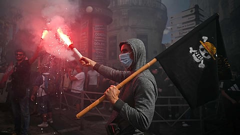  A protester holds a smoke flare and waves a pirate flag during a demonstration in Montpellier, southern France