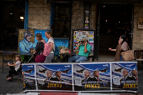 People walk next to a Likud party campaign ad featuring Israeli Prime Minister Benjamin Netanyahu and U.S. President Donald Trump, with a Hebrew message reading "We have one opportunity to win," in Jerusalem on Wednesday, Oct. 28, 2026, a day after the elections in Israel.