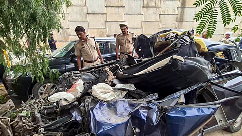 Police personnel stand near wreckage of a car after it rammed into the rear of a stationary bus on the Delhi-Vadodara Expressway near Sohna, in Gurugram, Thursday, Oct. 29, 2026. 