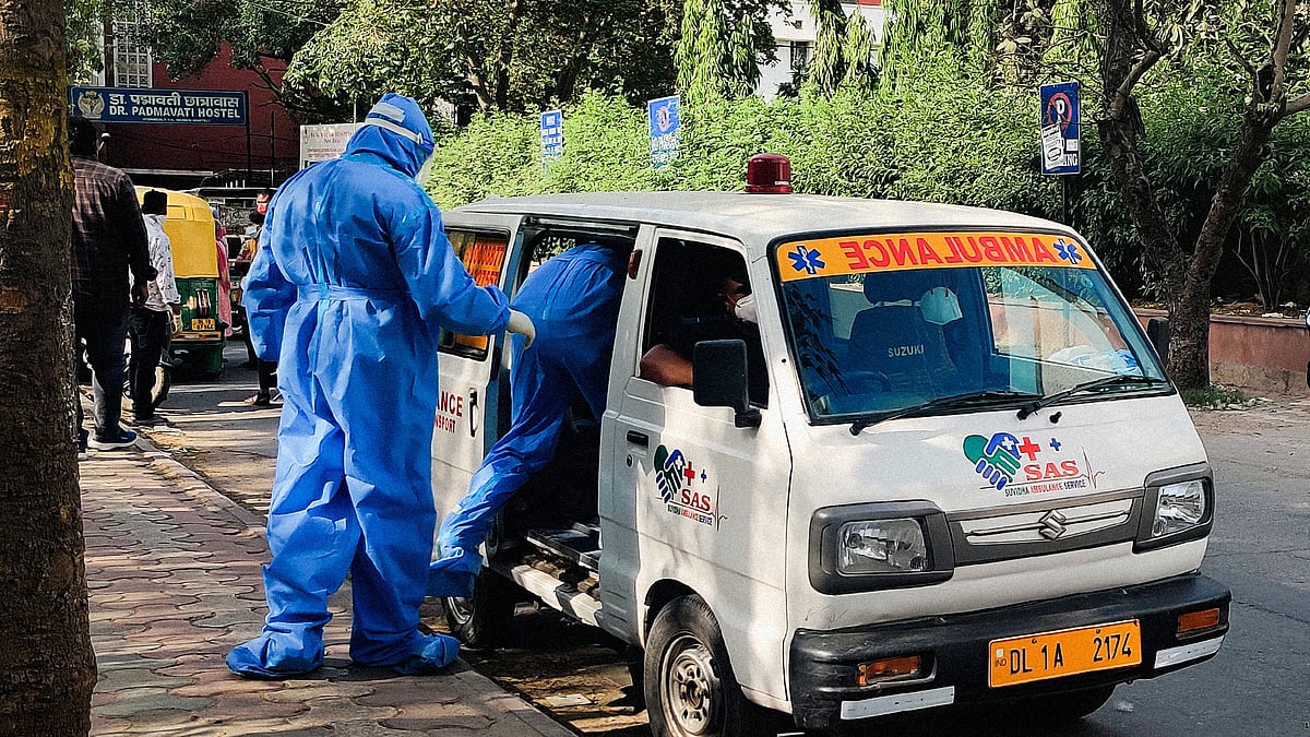 Mortuary workers accompany a body to assist with the last rites.