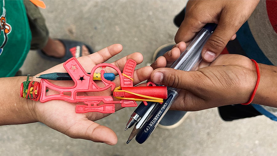 Young boys play with pens and a toy gun at St Mary’s relief camp. 
