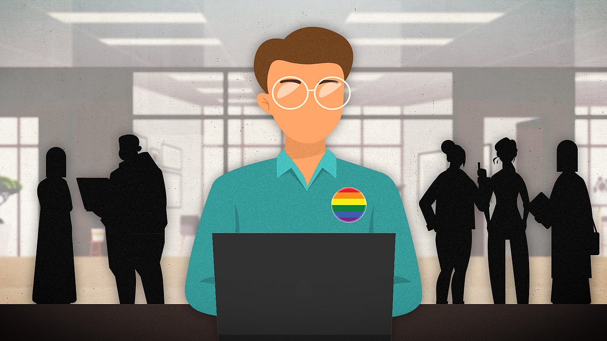 A person wearing a pride badge sitting in an office with figures standing behind him.