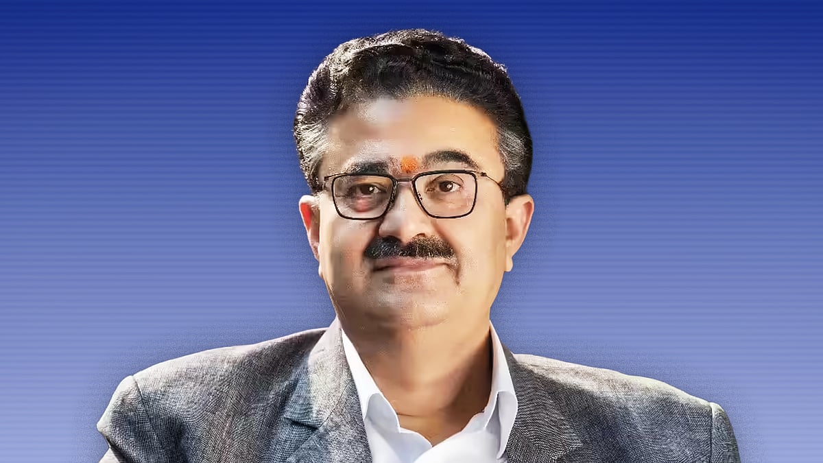 नवनीत सहगल ग्रे ब्लेज़र पहने हुए कैमरे की ओर देख रहे हैं.