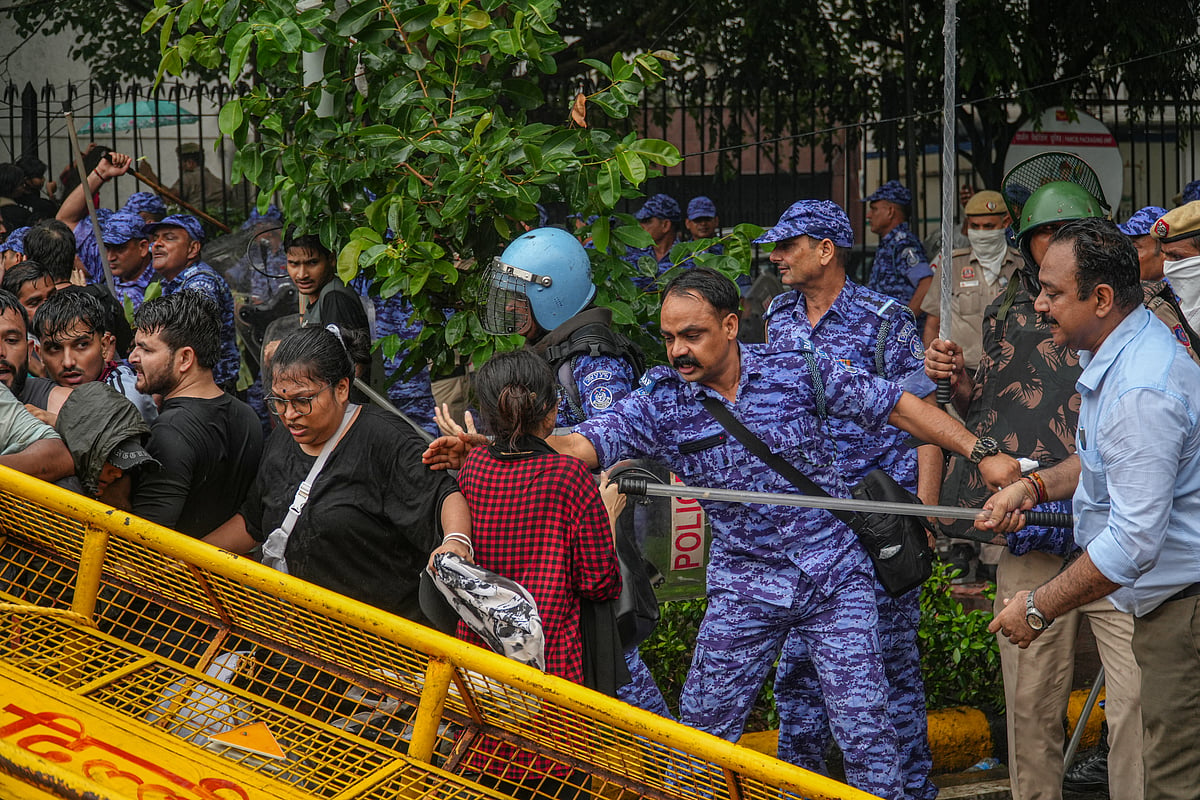 Caught in the lathi charge, a girl pleads with police not to hit her.