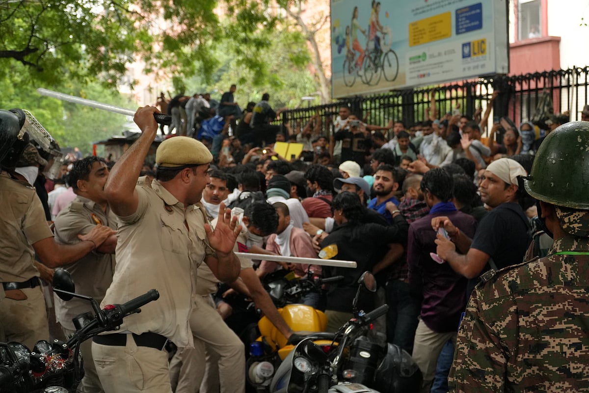Police disperse protesters with lathis.