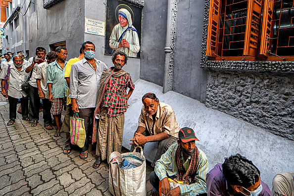 Avishek Das/SOPA Images/LightRocket via Getty Images : Underprivileged people stand in queues to receive food packets being distributed by the nuns from the Catholic Order of the Missionaries of Charity in Kolkata