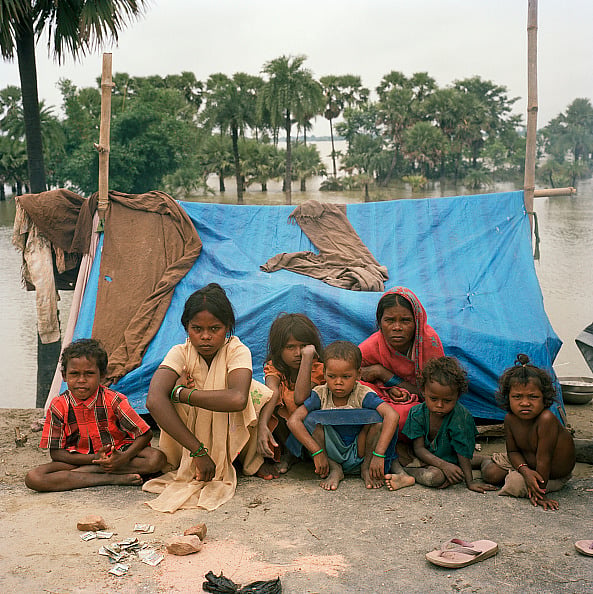 Getty Images : Belonging to the Musahar community (backward caste), these two women who had to flee their villages twice due to flooding, are forced to stay in makeshift plastic shelters set up on a road embankment in Bihar.
