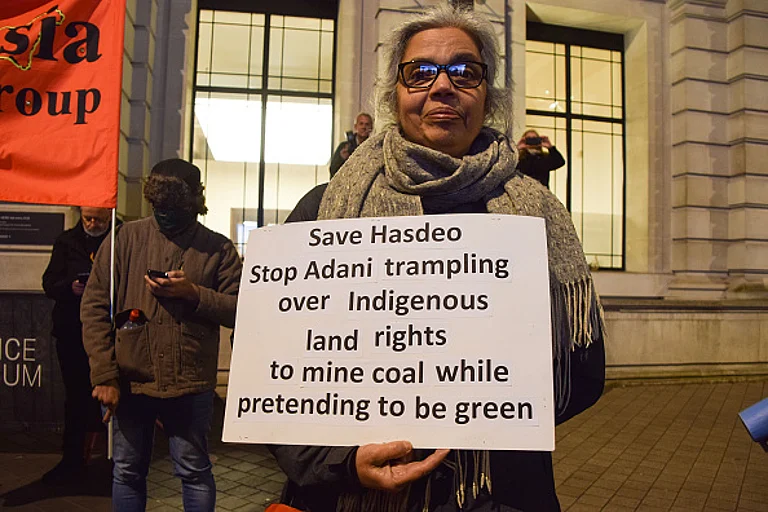 A demonstrator holds an anti- Adani and save Hasdeo placard during the protest. - Getty Images
