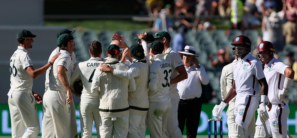 AP Photo/James Elsby : Australia players celebrate the fall of a West Indies wicket on Day 2 of their first Test cricket match in Adelaide, Australia on January 18, 2024.