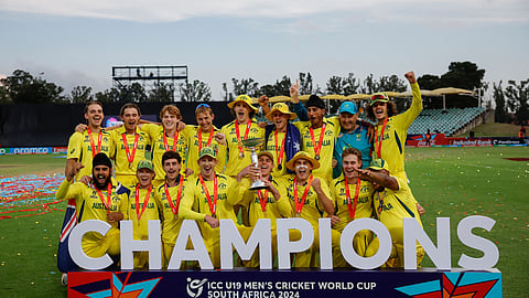 Hugh Weibgen, captain, and Harry Dixon lift the ICC Men's U-19 Cricket World Cup trophy as Australian players pose for a team photograph after beating India in the Benoni final on February 11, 2024.