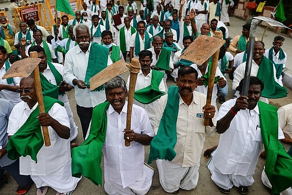 Getty Images : Members of a farmers association hold shovels to simulate begging as they protest against the central government's recent agricultural reforms in Chennai in 2020.