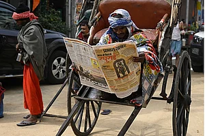Getty Images : A Rickshaw puller reads Newspaper on Ram Lalla idol consecration at Ayodhya (representative image)