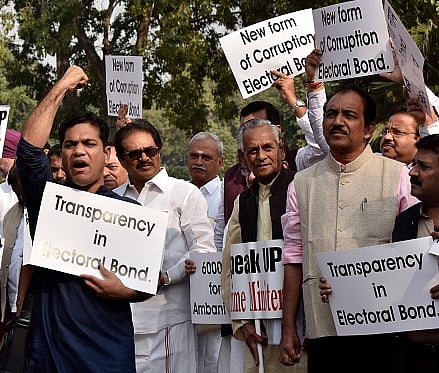 Mohd Zakir/Hindustan Times via Getty Images) : MPs protest against the issue of electoral bonds in the Parliament premises during the Winter Session, demanding that Prime Minister Narendra Modi breaks his silence over it, on November 22, 2019 in New Delhi, India