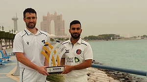 Photo: X/ @cricketireland : Ireland captain Andrew Balbirnie and Afghanistan captain Hashmatullah Shahidi with the one-off Test trophy in Abu Dhabi.