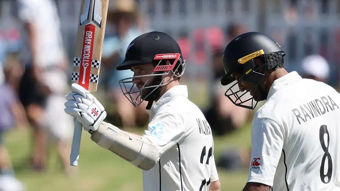 Kane Williamson (left) raises his bat after bringing up his ton. - X/tctv1offl