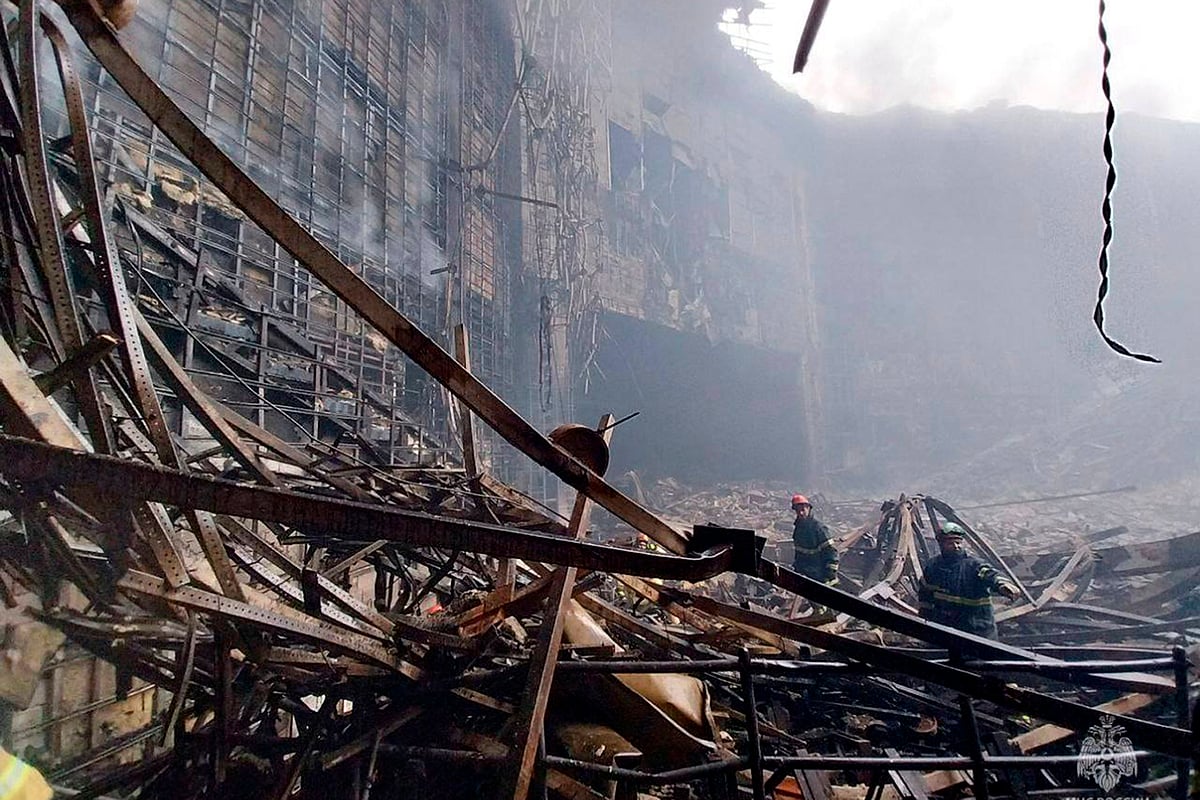 AP : In this photo released by Russian Emergency Ministry Press Service on Saturday, March 23, 2024, firefighters work in the burned concert hall after an attack on the building of the Crocus City Hall on the western edge of Moscow, Russia. 