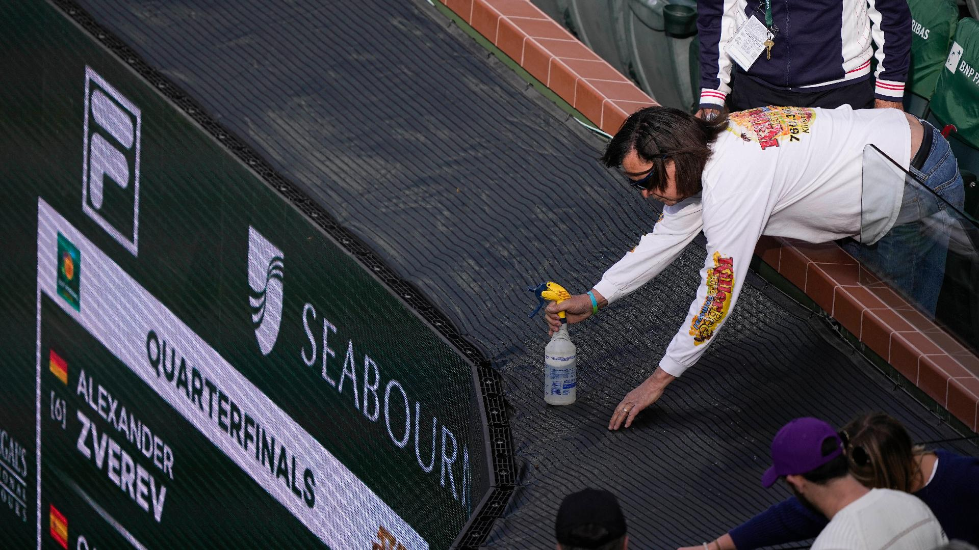 Mark J Terrill/AP : A beekeeper sprays a bee during an interruption in play at Indian Wells.