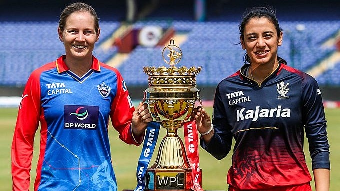 X/DelhiCapitals : DC skipper Meg Lanning (left) posing with the trophy alongside RCB skipper Smriti Mandhana.