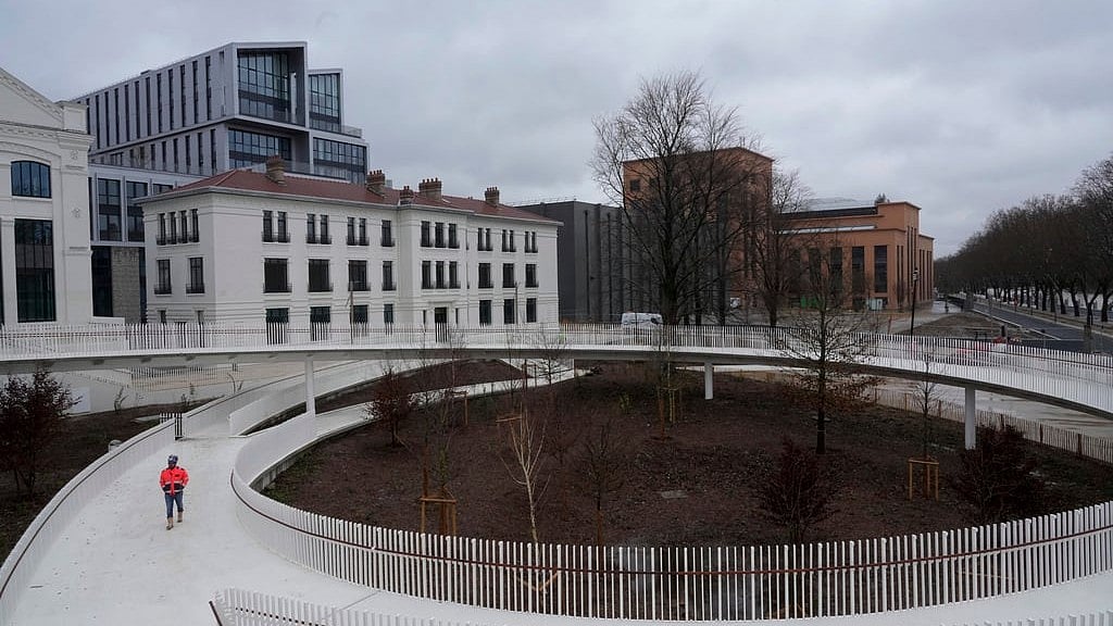 AP Photo/Thibault Camus : A worker walks in a street of the 2024 Olympic Games Village in Saint-Denis, north of Paris, ahead of its official inauguration on February 29.
