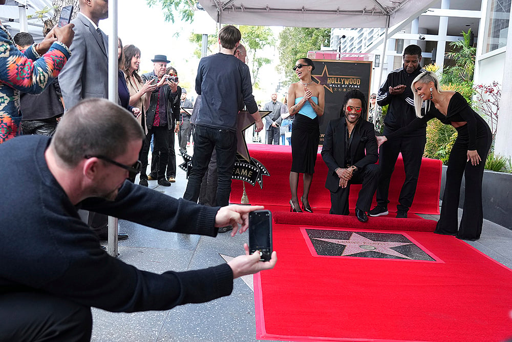 Jordan Strauss : Channing Tatum, far left, takes a picture of Zoe Kravitz, from left centre, Lenny Kravitz, Denzel Washington and Sibley Scoles at a ceremony honouring Lenny Kravitz with a star on the Hollywood Walk of Fame in Los Angeles.