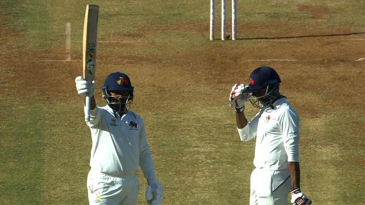 X/BCCIdomestic : Musheer Khan (left) raises his bat after bringing up his half-century in the Ranji Trophy final.
