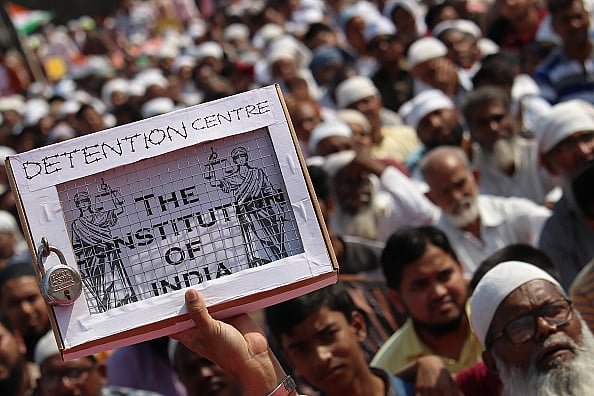 Getty Images : A demonstrator holds a placard during a protest against CAA and NRC in Mumbai, 15 February, 2020.