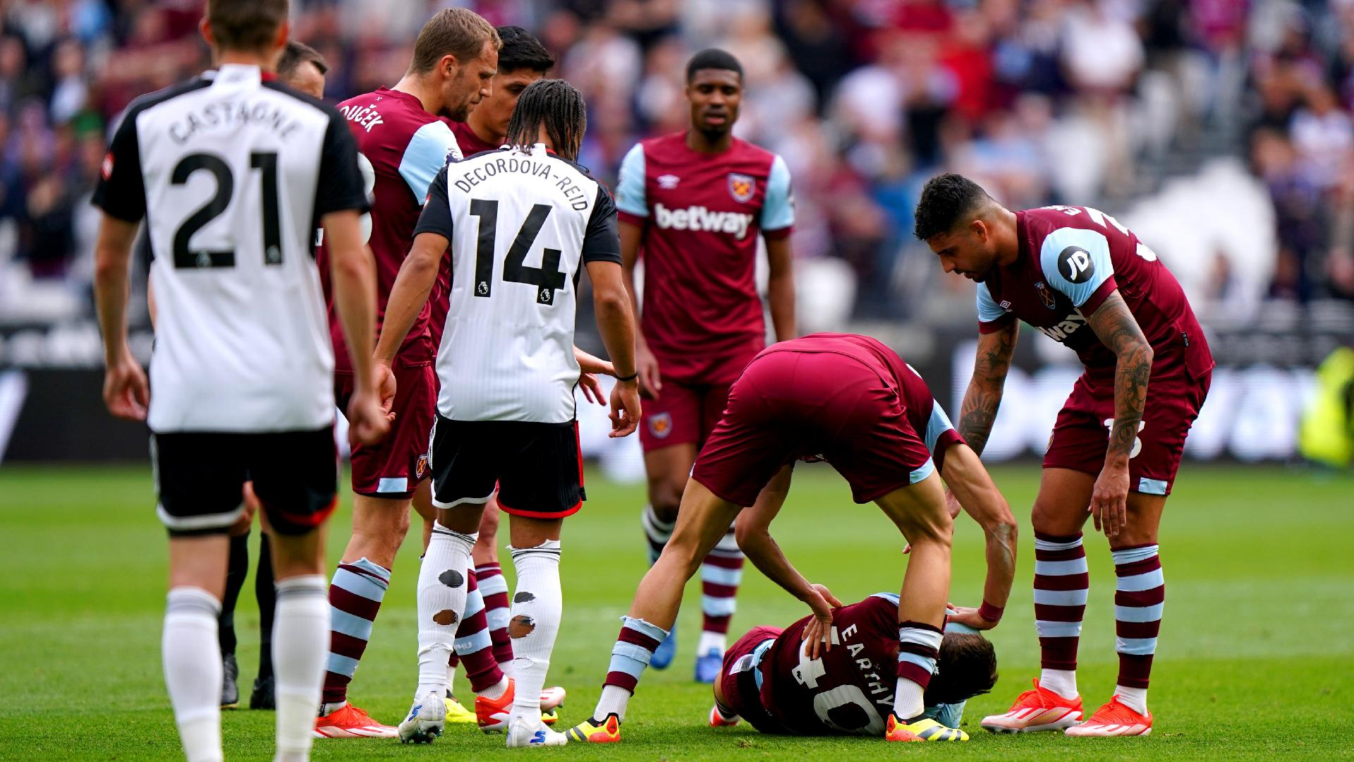 Bradley Collyer/PA : West Ham players come to the aid of team-mate George Earthy as he lies injured.