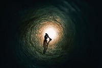 The Bee Sting: A Terrific Tragicomedy Photo: Getty Images : The silhouette of a teenage boy sitting and praying at the end of a tunnel with a bright light at the end